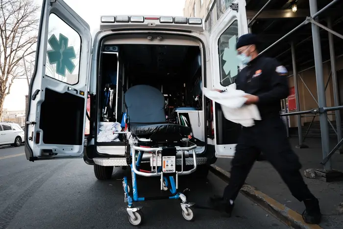 An EMT worker cleans a gurney after transporting a suspected COVID patient outside of a Brooklyn hospital on March, 29 2021.